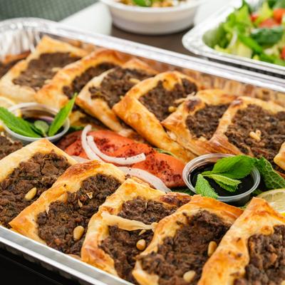 Lebanese meat pies in a catering dish.