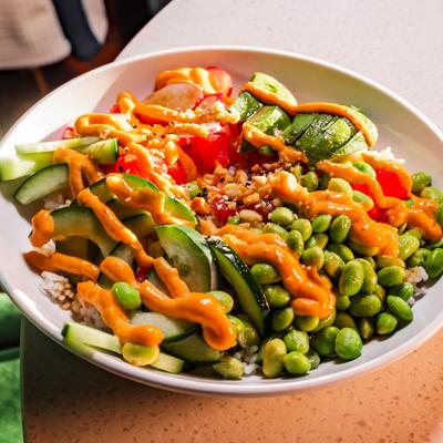Tuna Poke Bowl with rice, avocado, cucumber, radish, edamame and kimchi aioli.