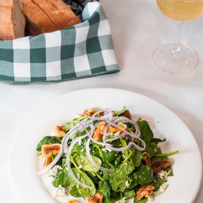 Baby spinach salad with figs, gorgonzola, walnuts, and onions, served with bread and wine.