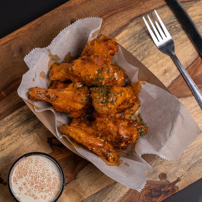 Honey Hot Wings served with a dip on the side.