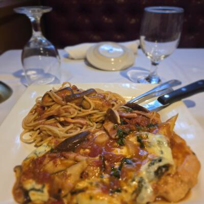 A served pasta dish with meat in melted cheese.