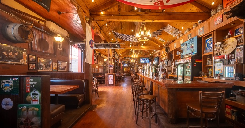 Interior with wooden beams, a long bar, and decorated walls.