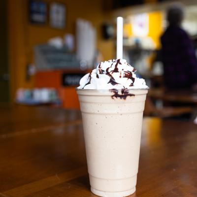 Frappe topped with whipped cream and chocolate drizzle.
