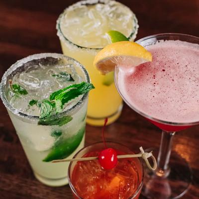 Colorful cocktails with fruit garnishes on a table.