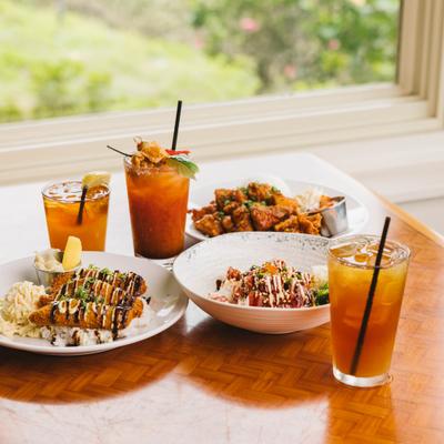 Assorted dishes and drinks on a restaurant table by a window.