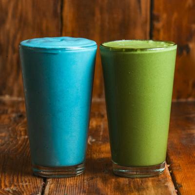 Two different smoothies served in tall glasses.