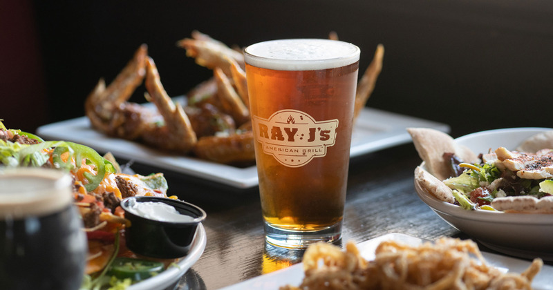 Glass of beer in the central position, various dishes around it