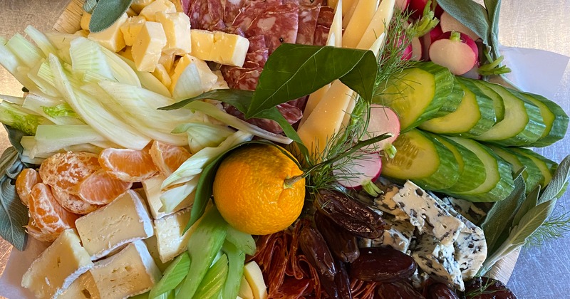 Charcuterie platter with meats, cheeses and sliced vegetables