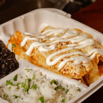 Enchiladas served with rice and beans.