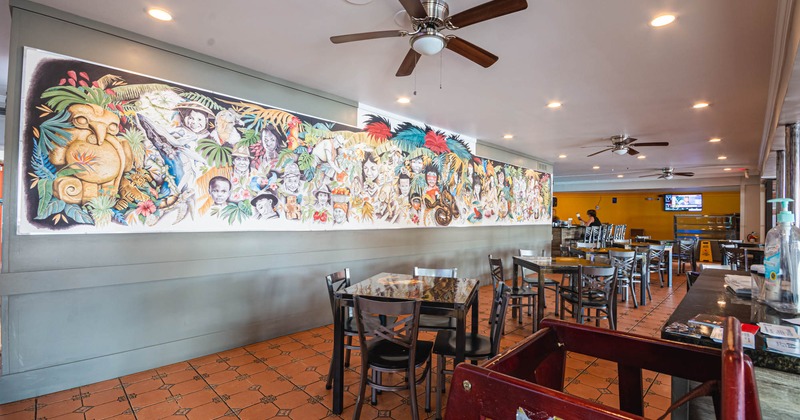 Mural with various people and animals on wall in dining area