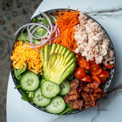A salad with avocado and bacon, top view.