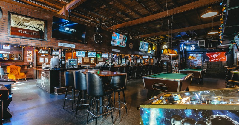 Interior seating and dining area, pool tables and TVs on the walls