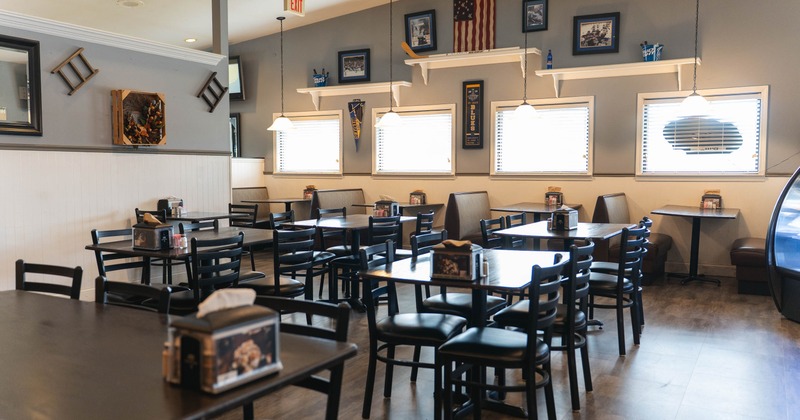 Interior, dark wooden tables and chairs, framed pictures and sports memorabilia on the walls