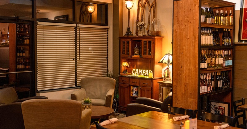 Interior, large wine shelf, four chairs with a round coffee table, vintage wooden cabinet