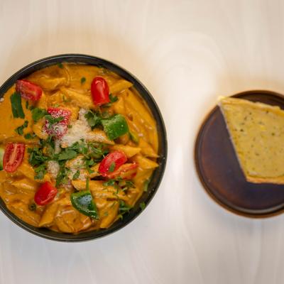 Top view of the Chicken Masala Alfredo Pasta with bread on the side.