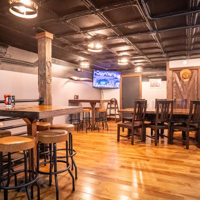 Interior, seating area, with tables, bar stools, chairs and rustic decor details.