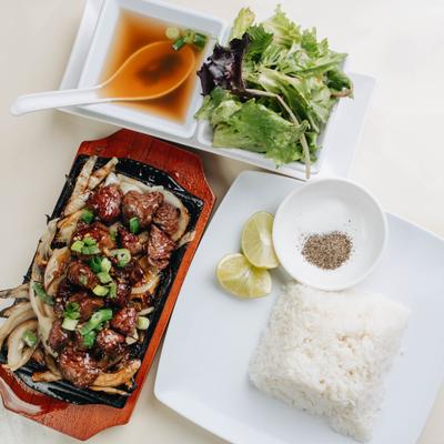 Seared Filet Mignon marinated in soy sauce, with grilled onions, rice, and salad.