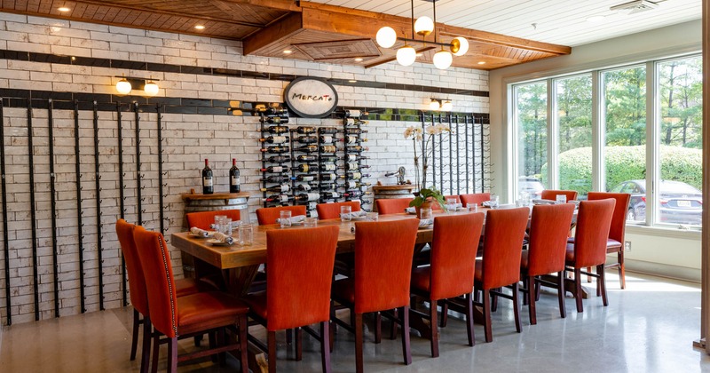 Interior, long dining set for guests, wine rack by the wall