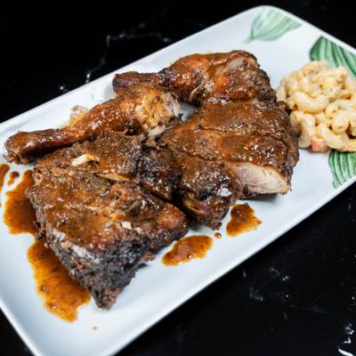 Jerk Chicken served with side of mac and cheese.