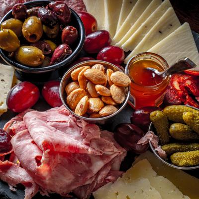 Grand board with meats cheeses olives and almonds.