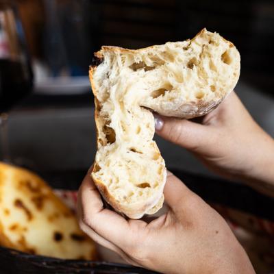 Georgian wheat bread (shotis puri) held up and cut in half to show interior