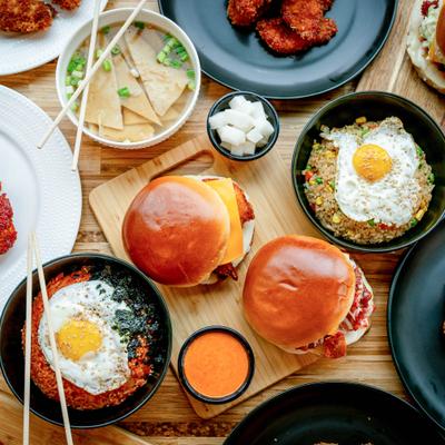 Top down photo of all the items in Gangnam Spice menu including Kimchi fried rice, chicken sandwiches, gochu-mayo dips, etc..