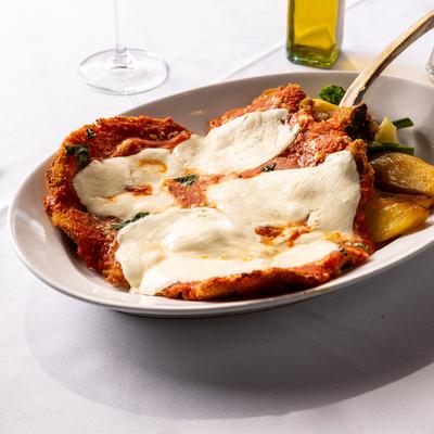Veal chop, with melted parmesan, potatoes, and veggies.