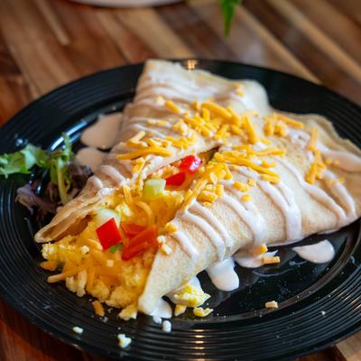 The Early Bird crepe with scrambled egg, cheese, green onions, and bell peppers.