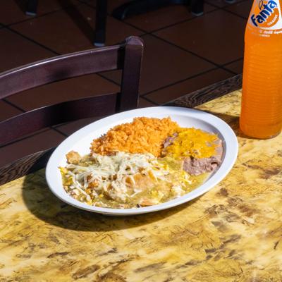 Chilaquiles with rice and beans, accompanied with a bottle of orange soda.