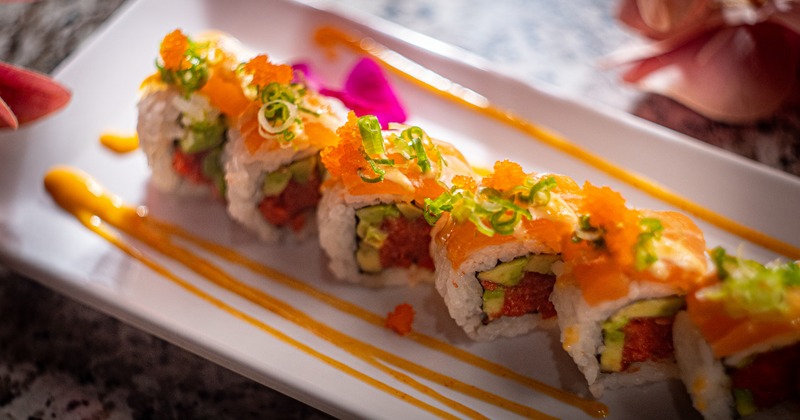 Spicy tuna sushi rolls, topped with salmon