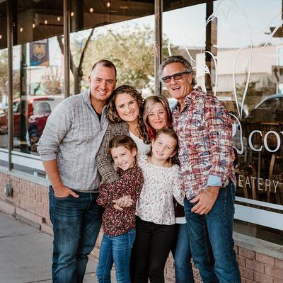 Owners posing with their family in front of the restaurant
