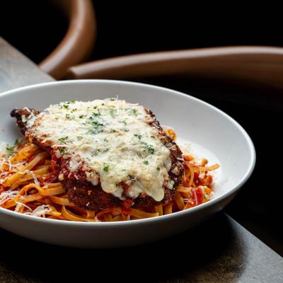 Breaded chicken cutlet topped with melted mozzarella and served over pasta.