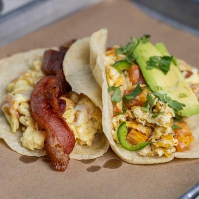 Breakfast tacos with scrambled eggs, bacon, and avocado.
