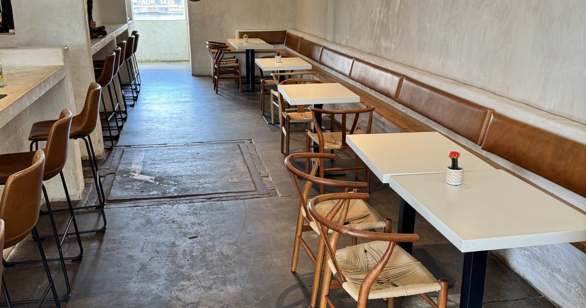 Minimalist restaurant with brown leather chairs and benches along a white wall