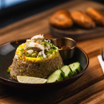 Crab Meat Fried Rice served with a sauce, cucamber slice and a lime wedge.