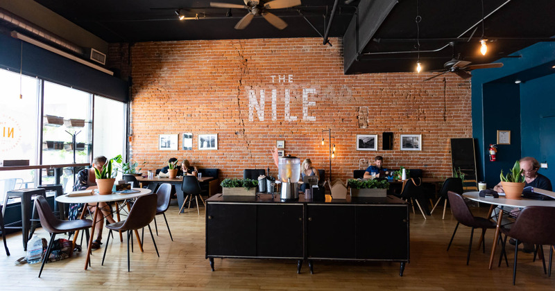 Interior - Orange-brownish brick wall with the sign "The Nile", modern furniture