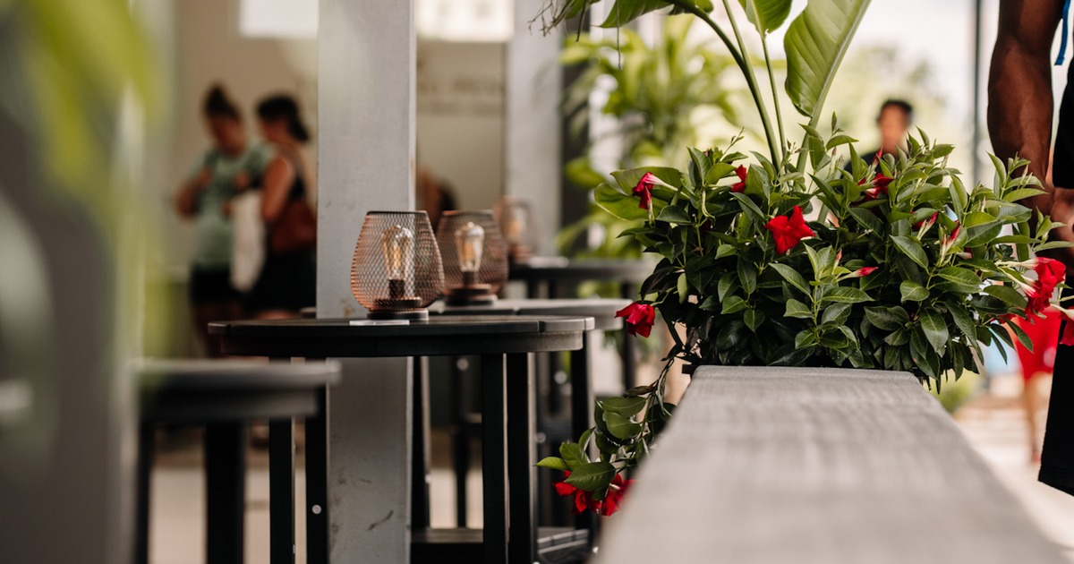 High wooden stools and tables with metal mesh lanterns