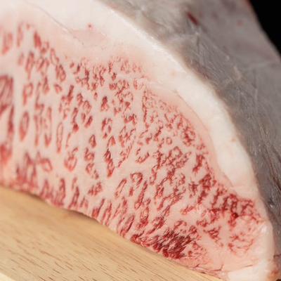 Close up of Kobe beef, emphasizing its fresh appearance and texture.