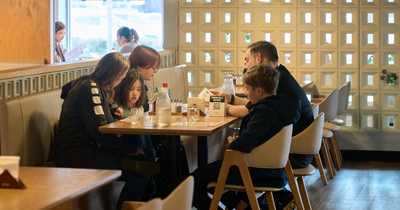 Interior, green panel walls, wooden tables and chairs