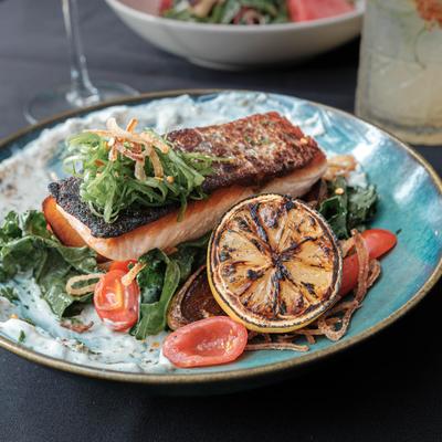 Pan seared salmon with cherry tomatoes and spinach,grilled lemon.