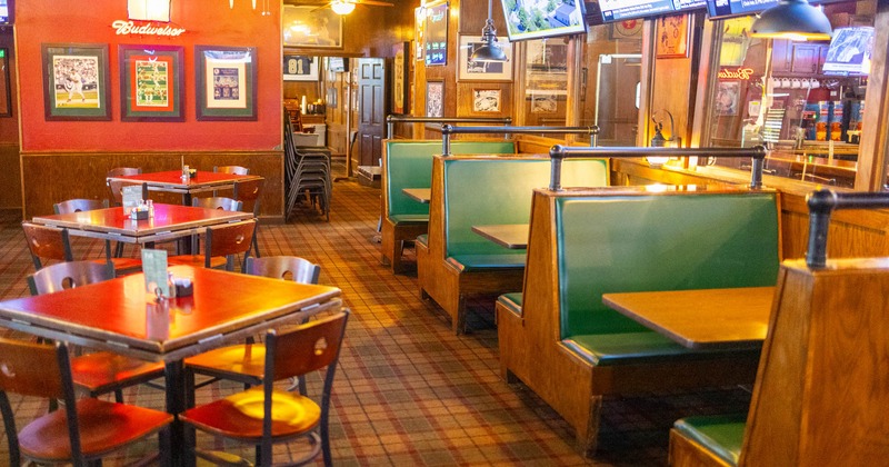 Interior, dining area, seating booths, tables for four, carpet flooring, framed pictures