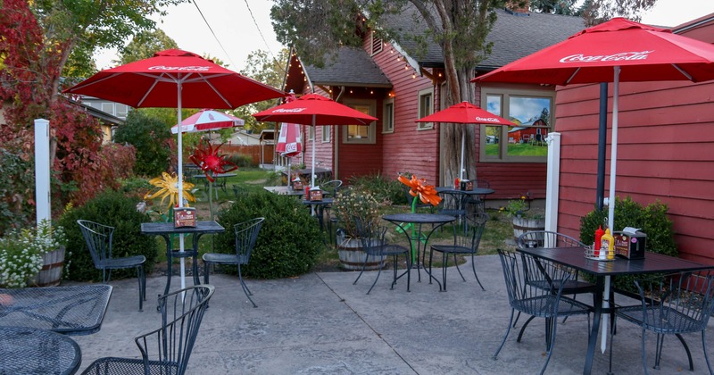 Outdoor patio with red umbrellas and metal tables and chairs