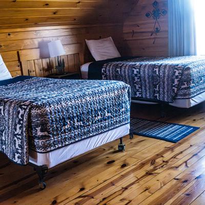 Cabin room wooden interior with two made beds.