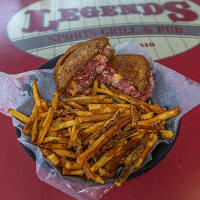 Reuben sandwich served with French fries.
