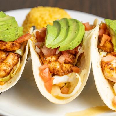 Shrimp Tacos, with avocado, honey lime slaw, salsa, rice, and sour cream.