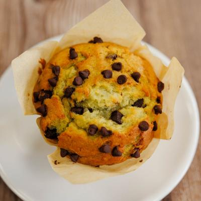 Chocolate chip muffin served on a white plate.