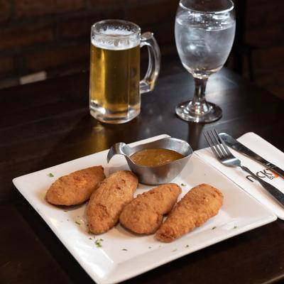Chicken tenders served with sauce and a beer.