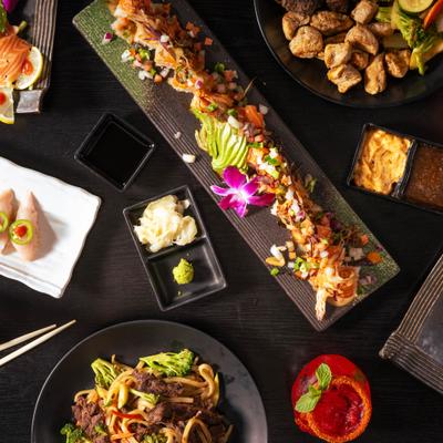 Various dishes and condiments served on the table with drinks.