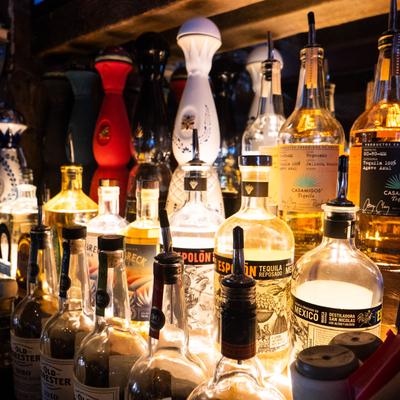 A collection of various tequila bottles displayed in a bar.