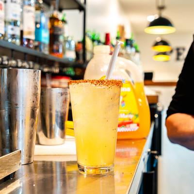 Chili-rimmed yellow cocktail at the bar.